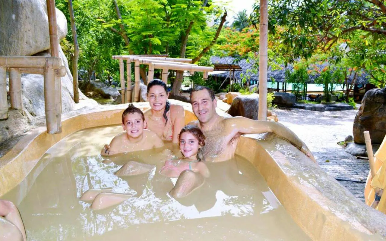 Family enjoying a bamboo hot tub at Cai River, Dubai.