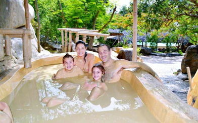Family enjoying a bamboo hot tub at Cai River, Dubai.