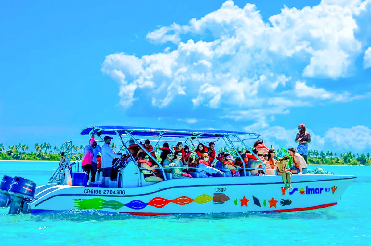 Tourists on a boat enjoying a day trip to Catalina Island from Santo Domingo, clear blue waters.