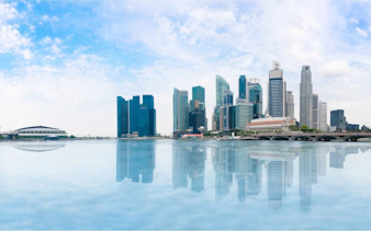Singapore skyline with Marina Bay Sands and skyscrapers reflected in water.