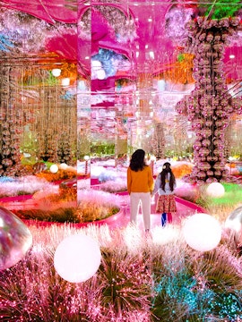 Visitors exploring a vibrant, mirrored art installation at House of Hype.