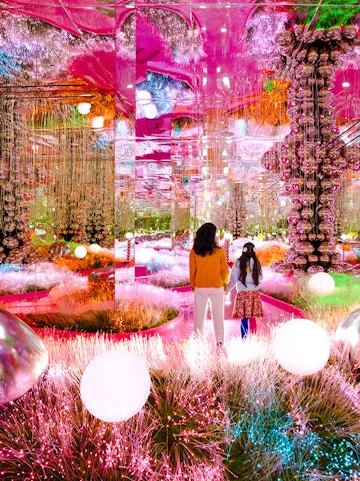 Visitors exploring a vibrant, mirrored art installation at House of Hype.