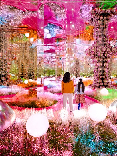 Visitors exploring a vibrant, mirrored art installation at House of Hype.
