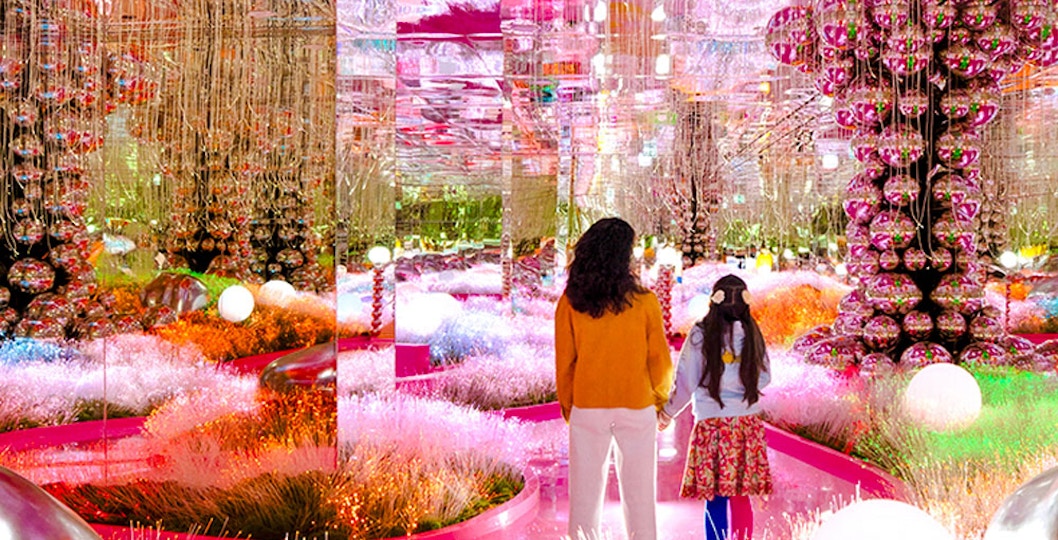 Visitors exploring a vibrant, mirrored art installation at House of Hype.