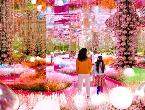Visitors exploring a vibrant, mirrored art installation at House of Hype.
