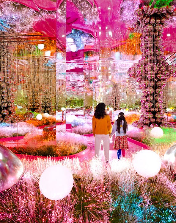 Visitors exploring a vibrant, mirrored art installation at House of Hype.