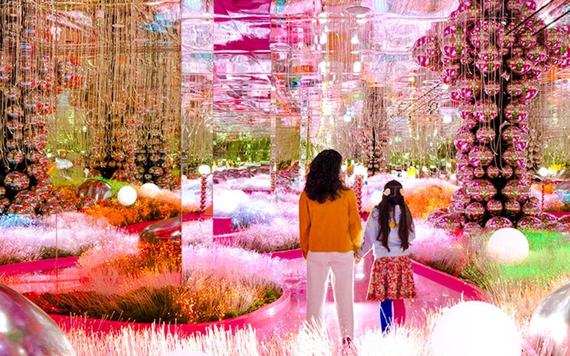 Visitors exploring a vibrant, mirrored art installation at House of Hype.