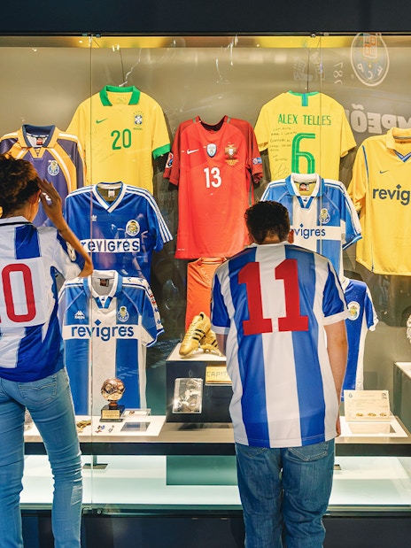Visitors at FC Porto stadium museum viewing historic jerseys display.