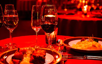 Rojo Tango Show Dinner table setting with wine glasses and gourmet dishes.