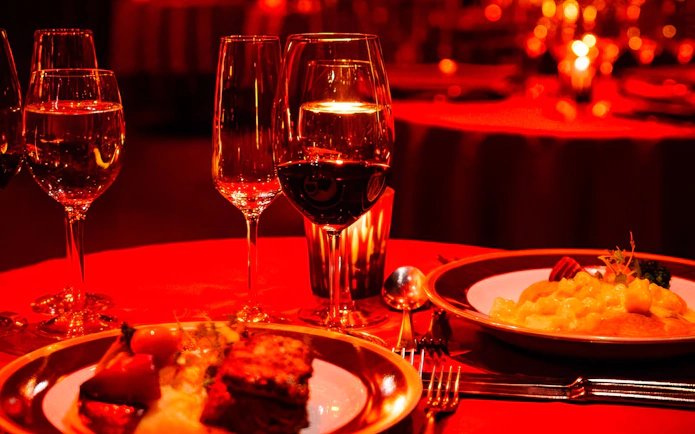 Rojo Tango Show Dinner table setting with wine glasses and gourmet dishes.