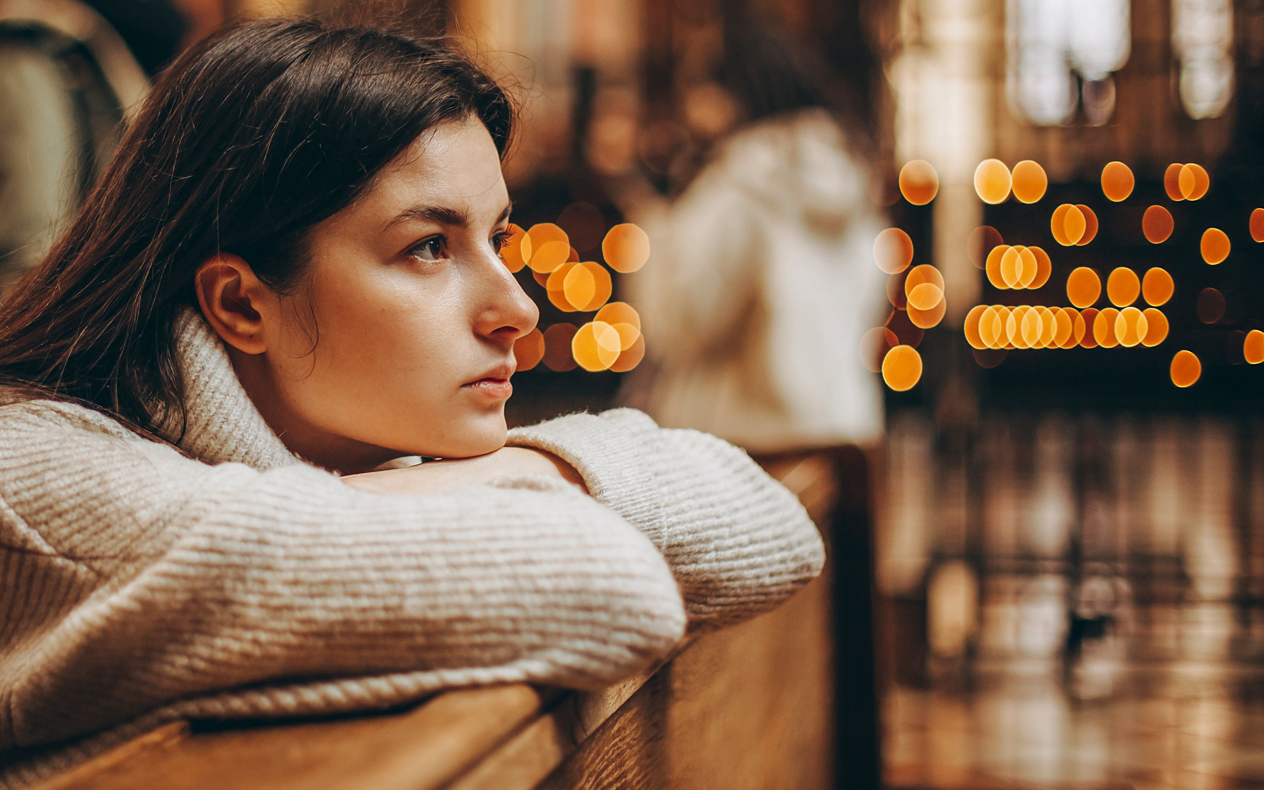 Person sitting in Canterbury Cathedral during Christmas service, with blurred lights in the background.