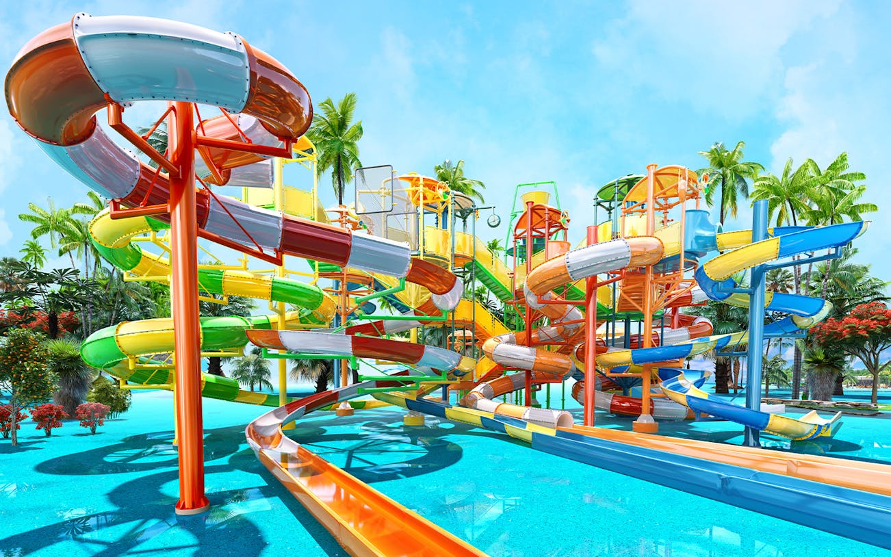 Colorful water slides at Aqualand surrounded by palm trees.