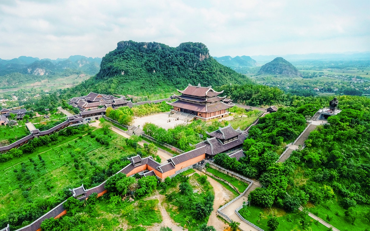 Bái Đính Pagoda complex with lush greenery and mountains in Ninh Bình, Vietnam.