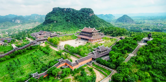 Bái Đính Pagoda complex with lush greenery and mountains in Ninh Bình, Vietnam.