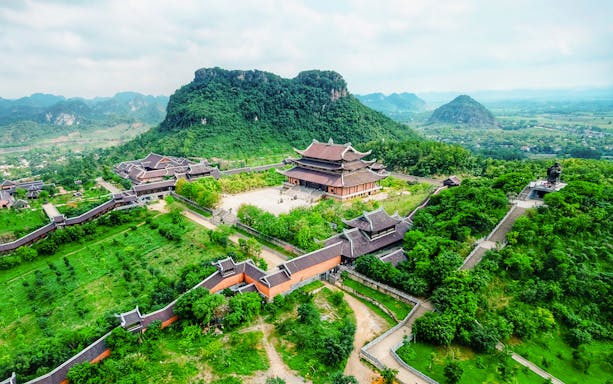 Bái Đính Pagoda complex with lush greenery and mountains in Ninh Bình, Vietnam.