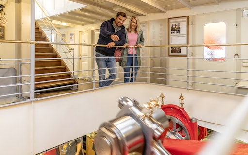 Couple exploring the engine room on the Gotthard Panorama Express boat.
