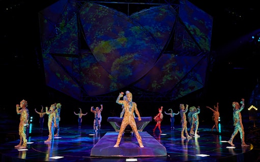 Performers in colorful costumes on stage during Mystère show.