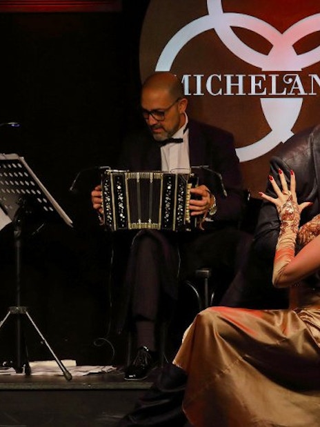 Dancers performing tango at Michelangelo Show with musicians playing bandoneons.