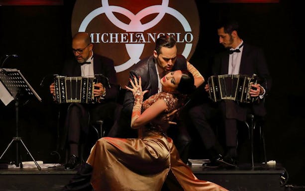 Dancers performing tango at Michelangelo Show with musicians playing bandoneons.