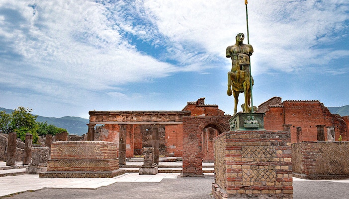 Ancient ruins of Pompeii with Mount Vesuvius in the background, part of the Pompeii daily tour from Naples.