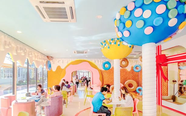 Visitors enjoying a colorful, candy-themed cafe at Fairy Sweet Village.