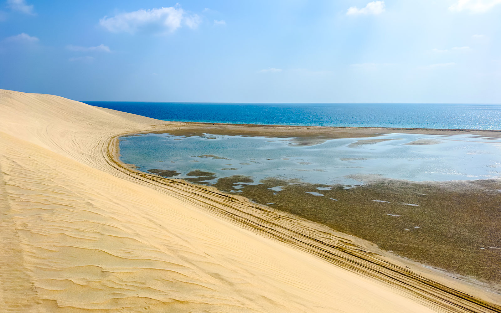 Sand dunes meeting the water at Khor Al Adaid, Inland Sea, Doha.