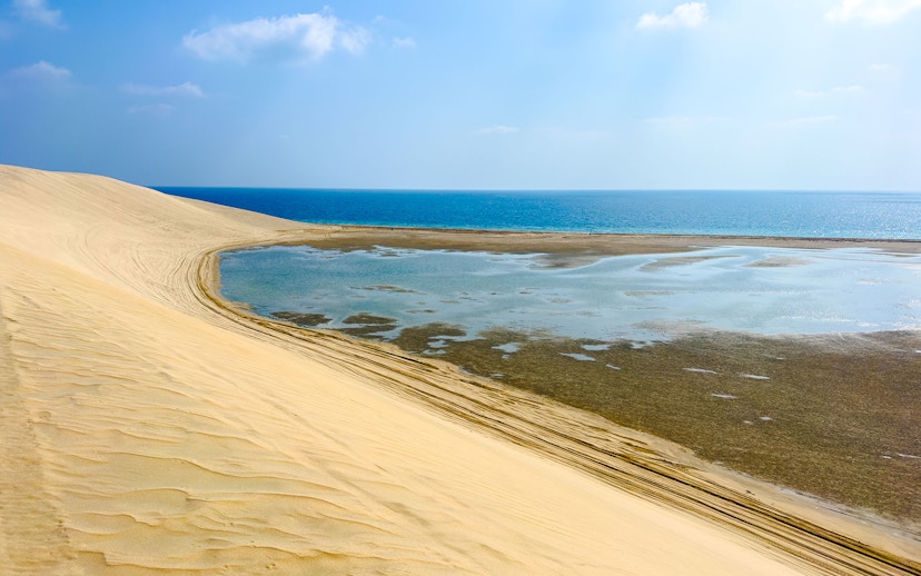 Sand dunes meeting the water at Khor Al Adaid, Inland Sea, Doha.