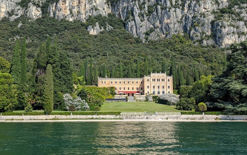 Elegant villa surrounded by lush greenery on Lake Garda during a 4-hour cruise to Sirmione.