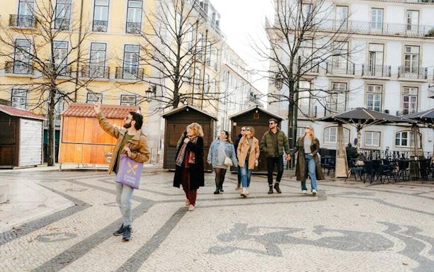 Tour group with guide exploring Lisbon street during food tour.