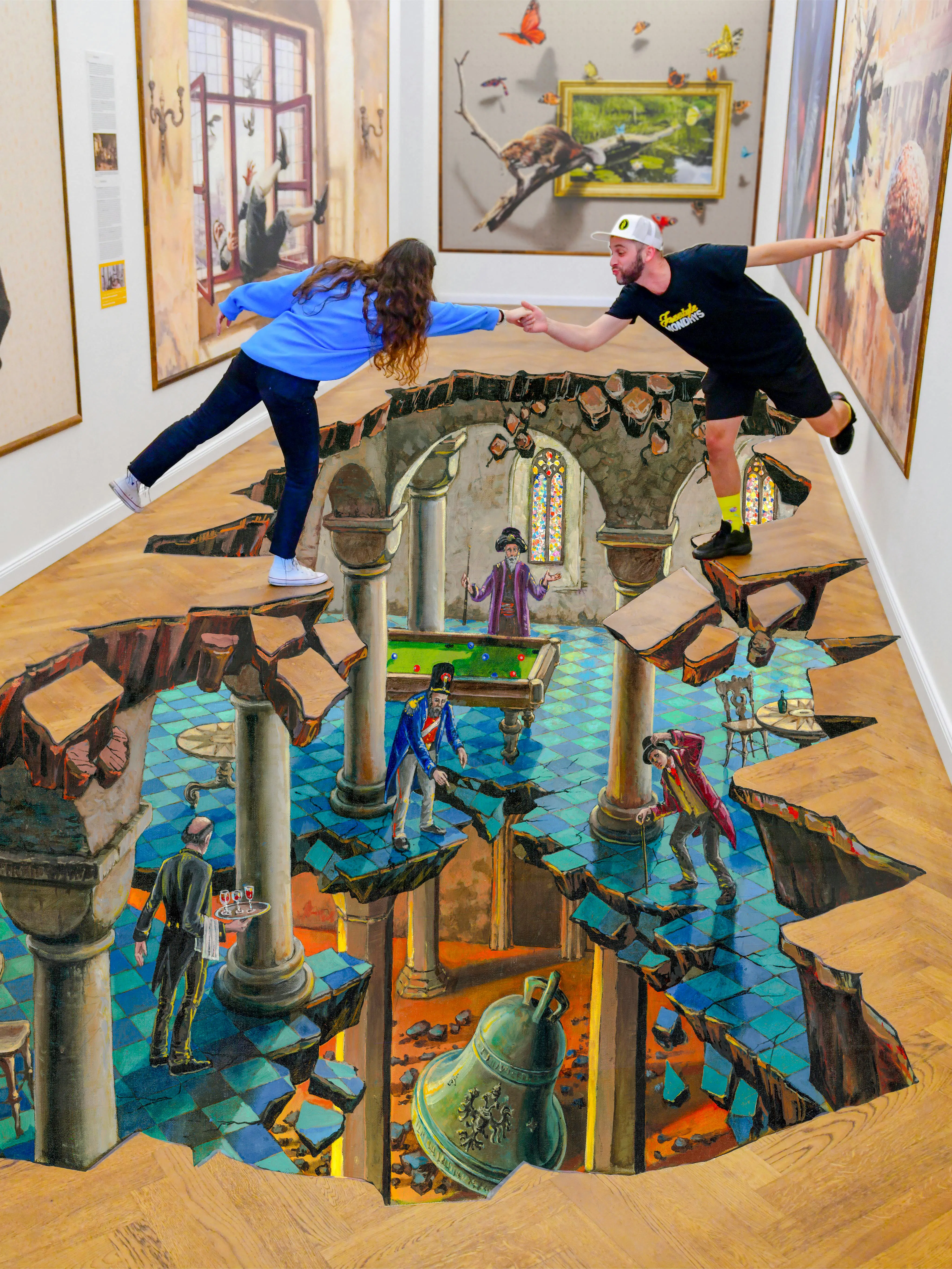 Visitors interacting with 3D floor art at IAM Illusion Art Museum, Prague.