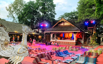 Chiang Mai Khan Toke dinner setup with traditional stage and seating cushions.