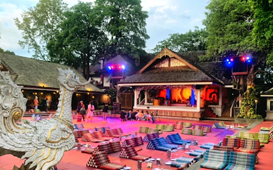Chiang Mai Khan Toke dinner setup with traditional stage and seating cushions.