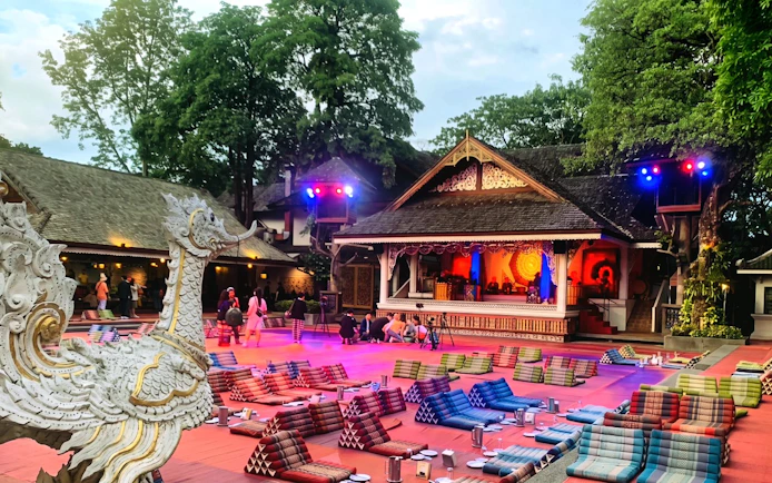 Chiang Mai Khan Toke dinner setup with traditional stage and seating cushions.