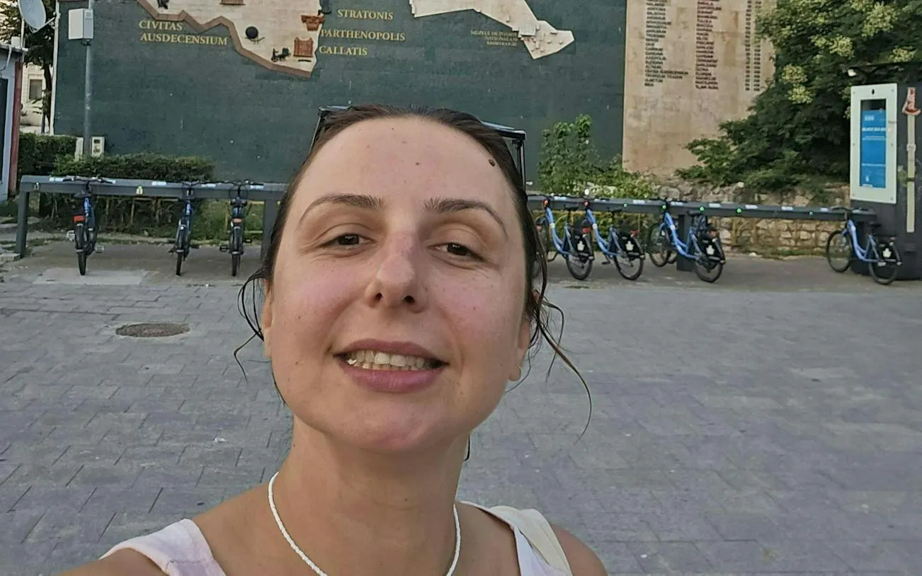 Selfie in front of historical map mural and bike station, Constanta city exploration game.