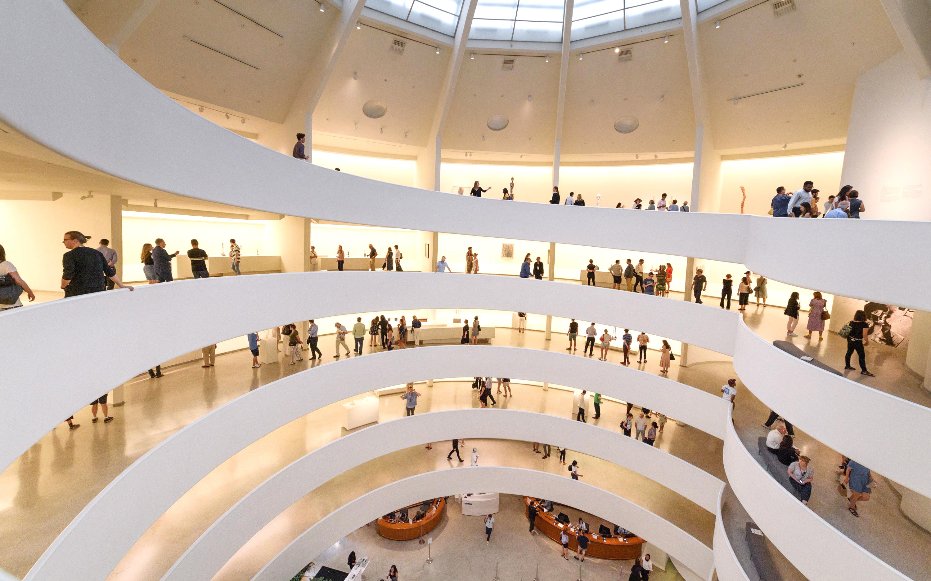 Visitors exploring the spiral ramps of the Guggenheim Museum interior in New York.