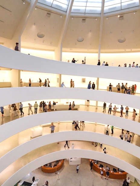 Visitors exploring the spiral ramps of the Guggenheim Museum interior in New York.