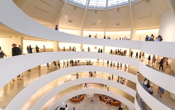 Visitors exploring the spiral ramps of the Guggenheim Museum interior in New York.