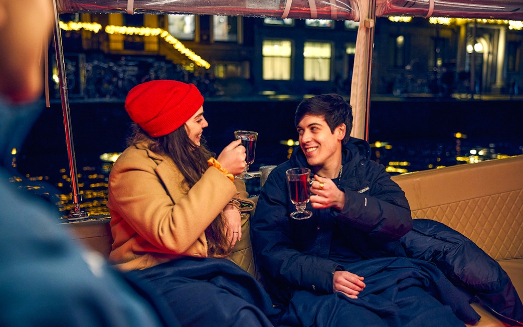 Couple enjoying mulled wine on Amsterdam Light Festival cruise.
