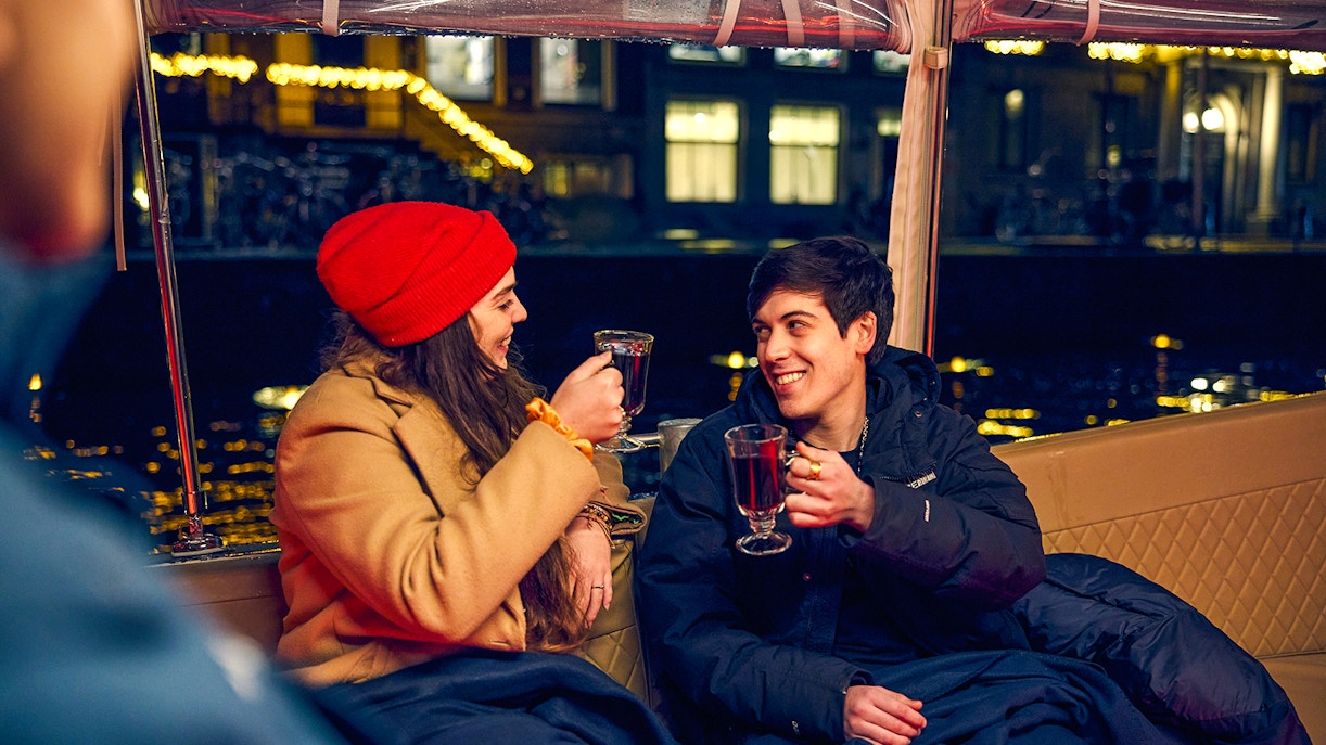 Couple enjoying mulled wine on Amsterdam Light Festival cruise.