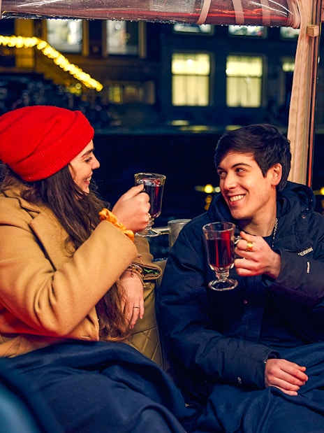 Couple enjoying mulled wine on Amsterdam Light Festival cruise.