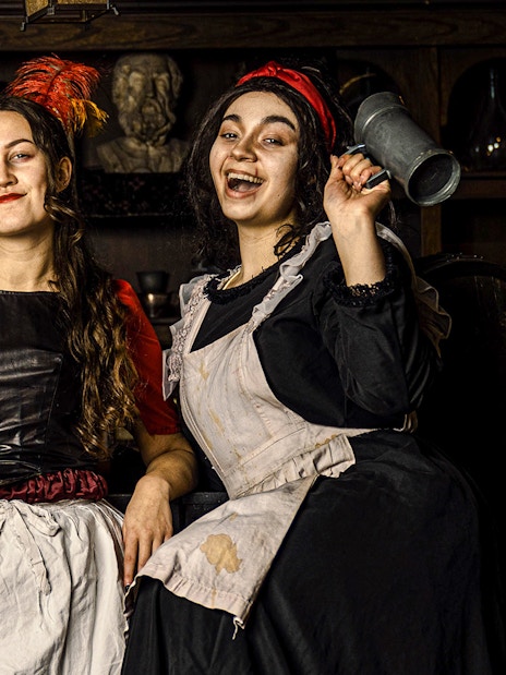 Guests in historical costumes at the Amsterdam Dungeon experience.