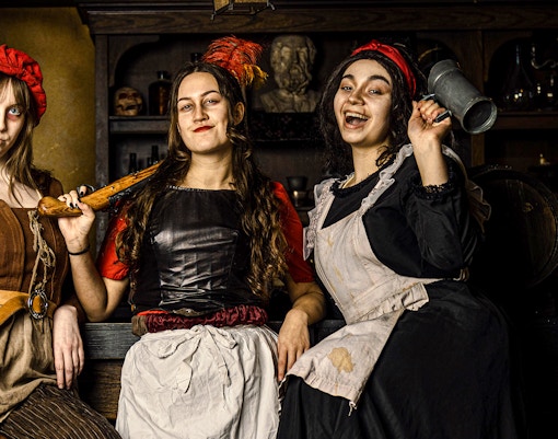 Guests in historical costumes at the Amsterdam Dungeon experience.