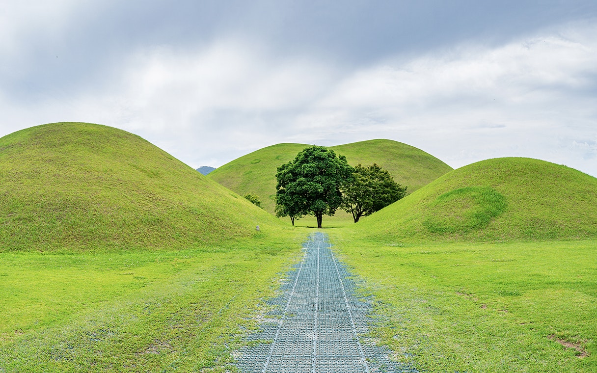 Pathway through grassy burial mounds in Gyeongju, South Korea, UNESCO World Heritage site.