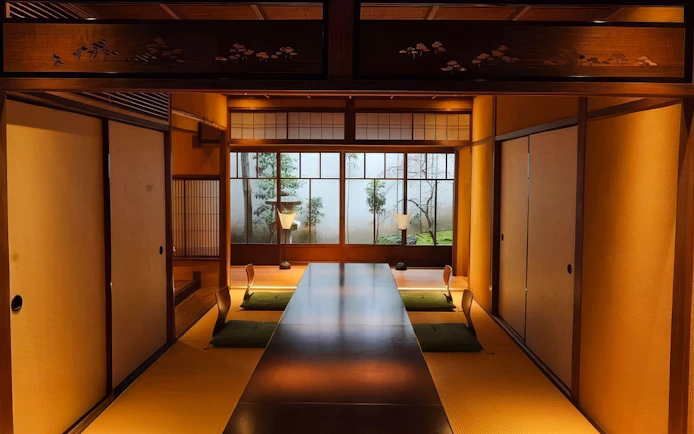 Traditional Japanese tea house interior with tatami mats and low seating for Geisha show.