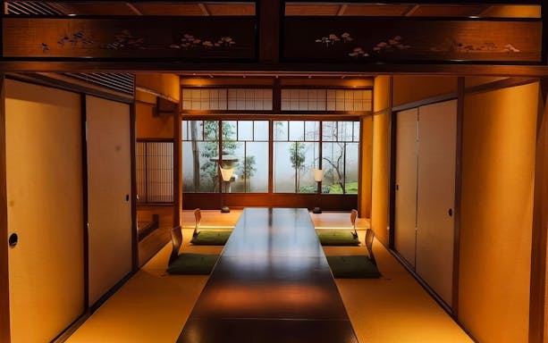 Traditional Japanese tea house interior with tatami mats and low seating for Geisha show.