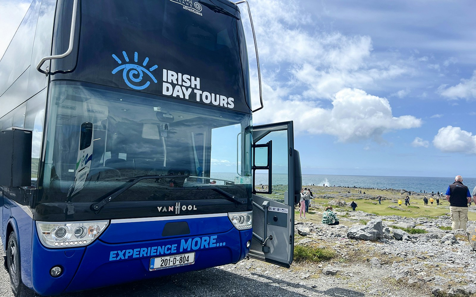 Bus for Irish Day Tours parked near Cliffs of Moher with ocean view.