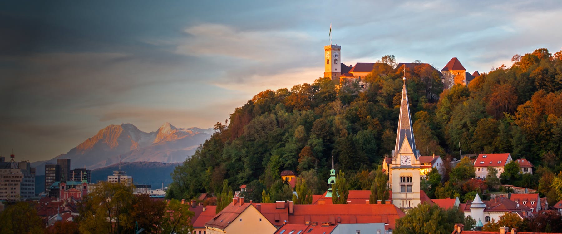 Ljubljana Castle on a hill with cityscape and mountains in the background, Slovenia.