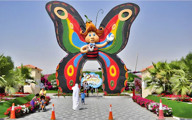 Entrance to Dubai Butterfly Garden with colorful butterfly arch and visitors.