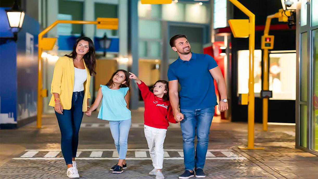 Family exploring KidZania Singapore indoor city attractions.
