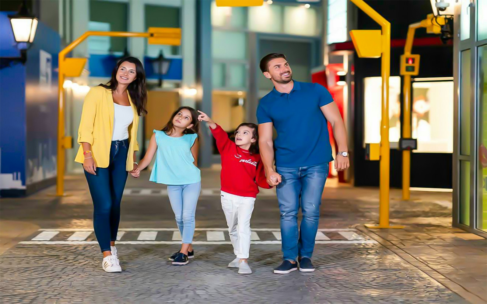 Family exploring KidZania Abu Dhabi indoor city attractions.